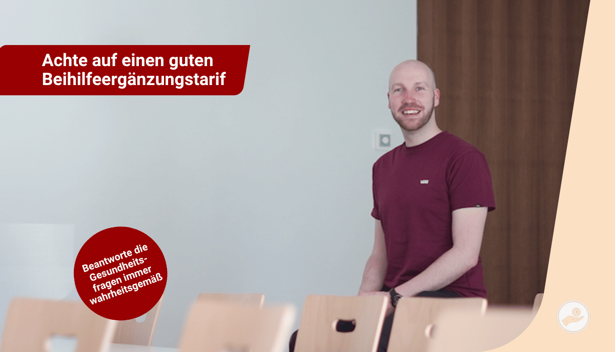 Hendrik Hamel sitzt lächelnd in einem Klassenraum mit Hinweis zur Beihilfeergänzungstarif und Gesundheitserklärung